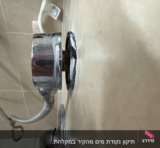 חלקי אינסטלציה עם צינור מתכת על קיר קרמיקה